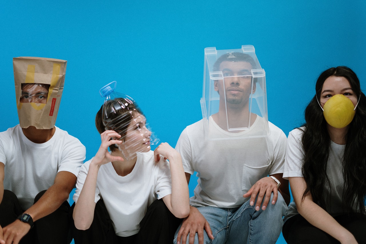 two men and two women posing with different types of plastic