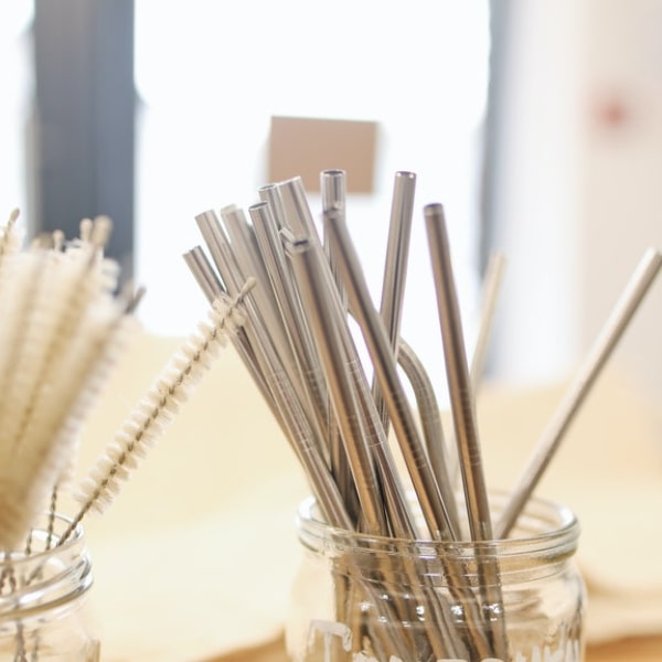mason jar full of stainless steel straws and cleaners