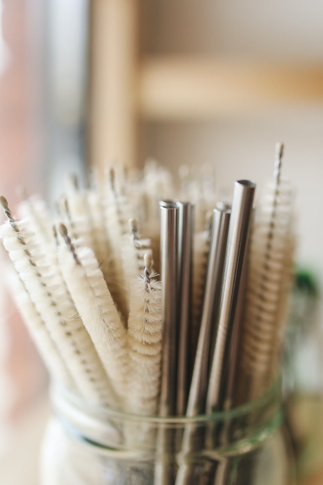mason jar full of stainless steel straws and cleaners