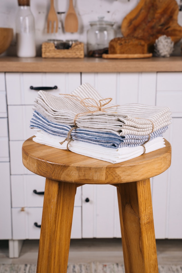 towels tied in twine sitting on wooden stool in kitchen 
