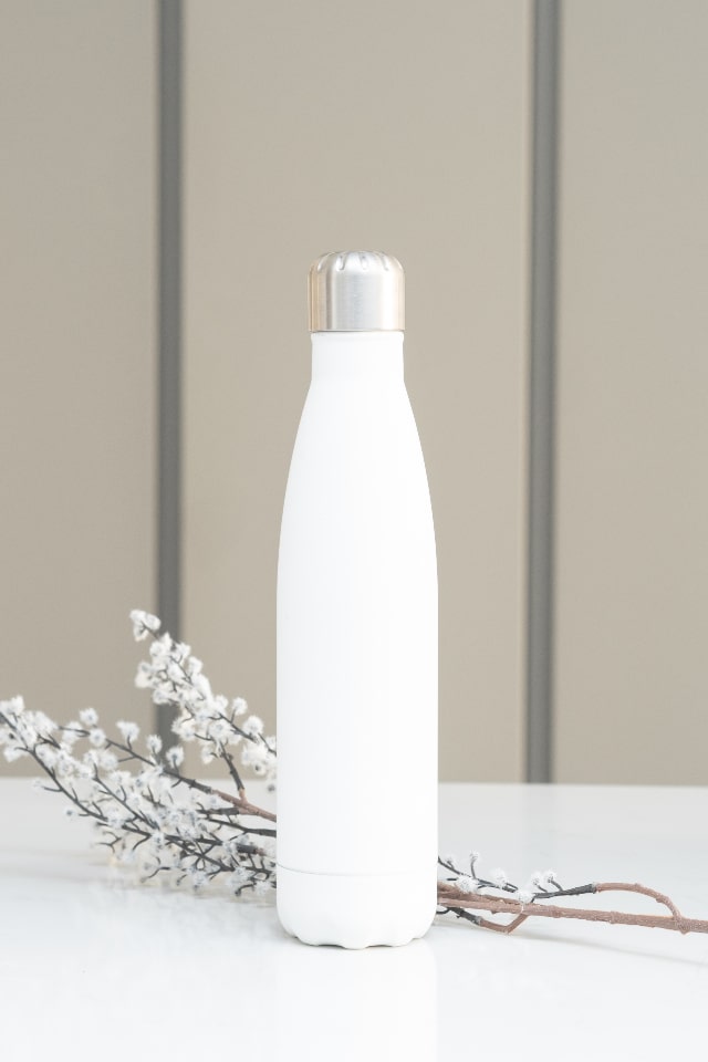 white stainless steel bottle staged with white flowers
